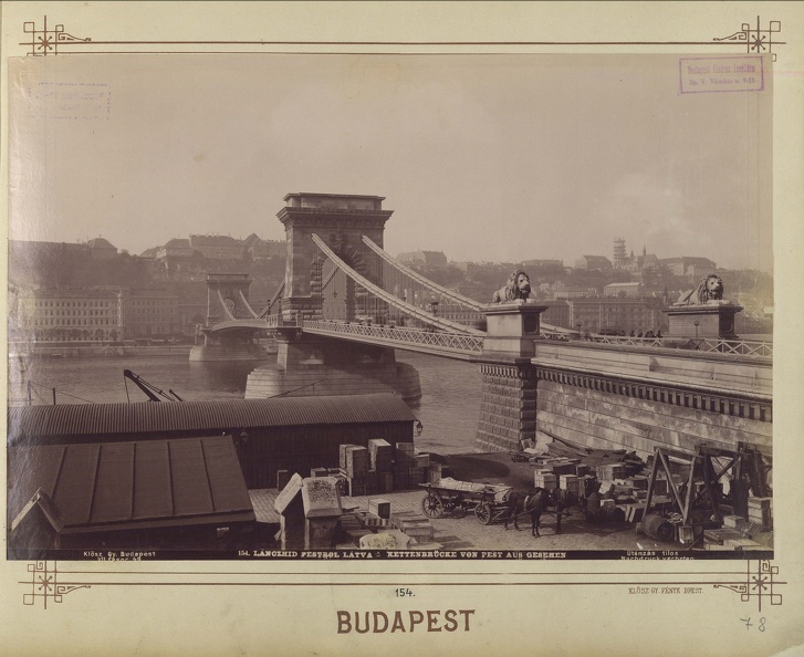 Lánchíd az Eötvös tér felől nézve. Előtérben a teherhajó kikötő raktárai a rakparton, háttérben a budai Vár. A felvétel 1893 körül készült. A kép forrását kérjük így adja meg: Fortepan / Budapest Főváros Levéltára. Levéltári jelzet: HU.BFL.XV.19.d.1.