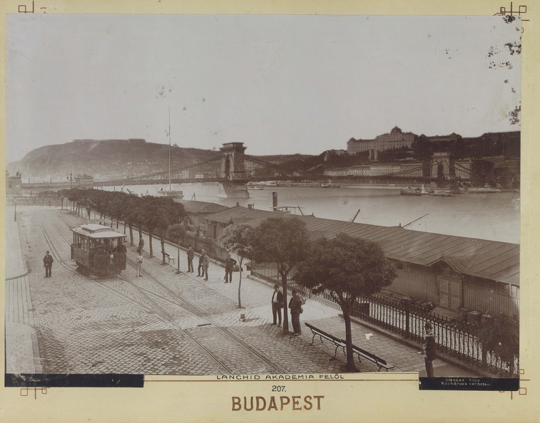 Villamos végállomás és a teherhajó kikötő raktárai a Széchenyi (Rudolf) rakparton az Arany János utca torkolatánál. Háttérben a Lánchíd és a Királyi Palota. A felvétel 1890 körül készült. A kép forrását kérjük így adja meg: Fortepan / Budapest Főváro