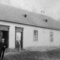 Petőfi utca 38., ifj. Probst Mihály vegyeskereskedése, háttérben az iskola épülete (ma Faluház).
