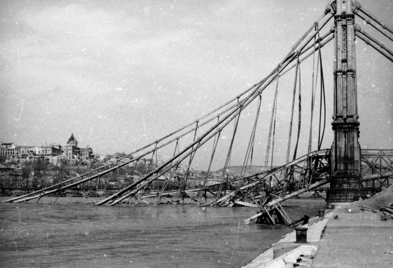 a lerombolt Erzsébet híd pesti hídfője az alsó rakpartról nézve, háttérben a romos Királyi Palota.