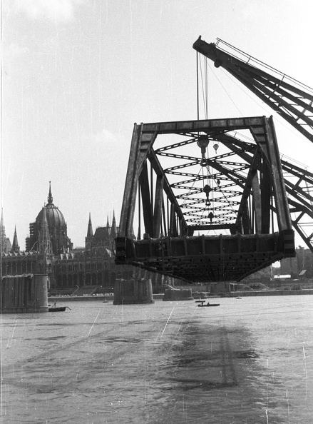 a Kossuth híd bontása. Úszódaruk viszik a Bem rakpartra a híd egyik medernyílásának vasszerkezetét.