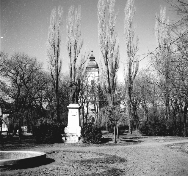 Petőfi tér, I. világháborús honvéd hősi emlékmű (Weisze Béla, 1930.), háttérben a református templom.