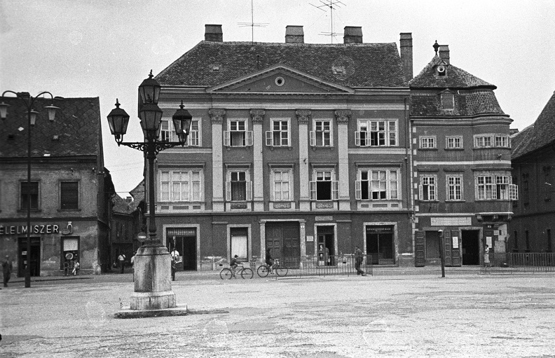 Széchenyi tér, balra a Kenyér köz torkolata. Jobbra a Stelczer Lajos utca sarkán a Vastuskós ház.