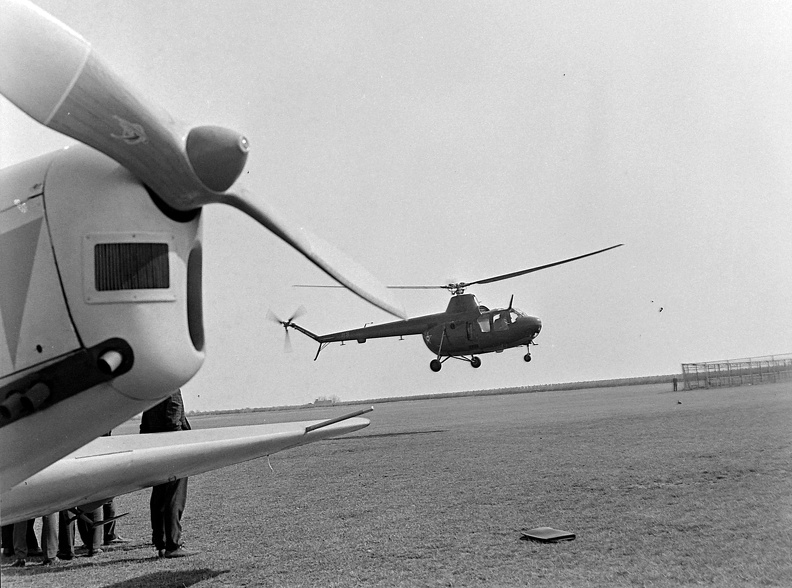Zlin Trener repülőgép az előtérben, a háttérben egy Mi-1 típusú katonai helikopter.