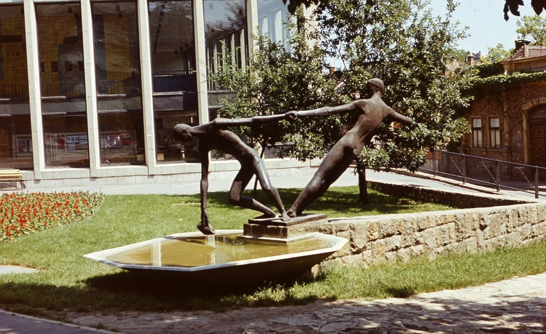 Görgey Artúr utca (Felszabadítók útja), Kiss Sándor "Vízmerítők" című szobra (1961), mögötte a Rónai Sándor művelődési központ.